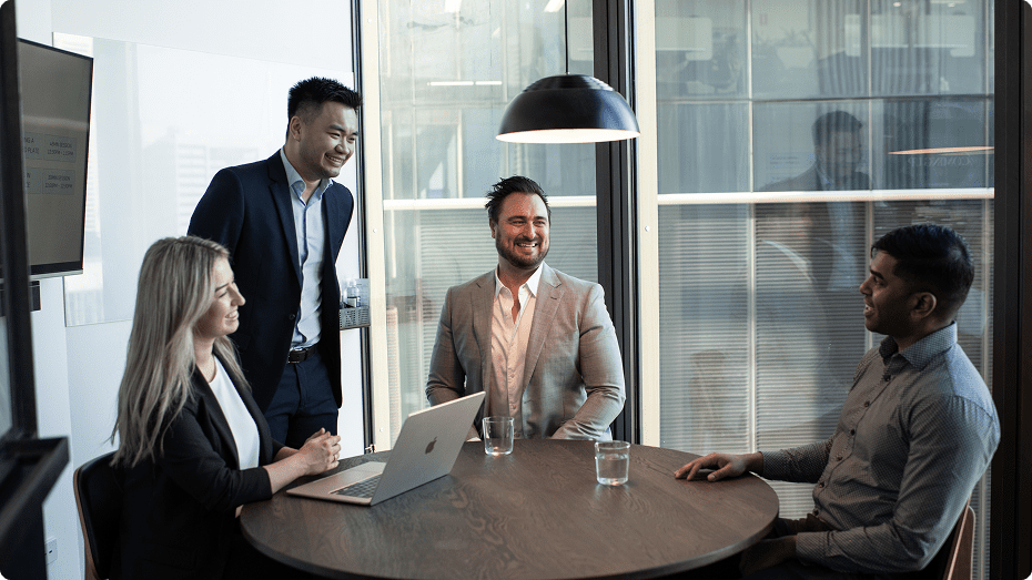 4 colleagues talking and smiling